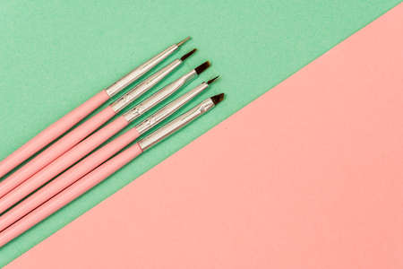 cosmetic flat lay: pink makeup brushes on green backgroundの写真素材