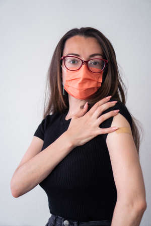 Girl with glasses and a protective mask after the  vaccineの写真素材