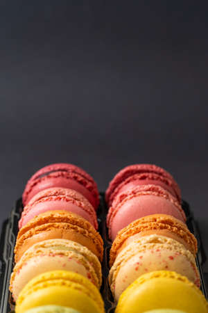Macarons on dark background, colorful french cookies macarons.