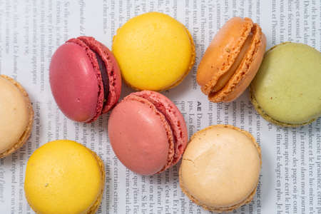 french dessert macarons of different colors, fashion magazine and dry flowers on a white background