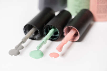 Nail polish in pink, green and gray colors. Drops of nail polish