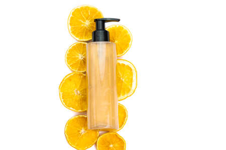 cosmetic flat lay: bronzer body glitter cream and juicy orange slices on a white backgroundの写真素材