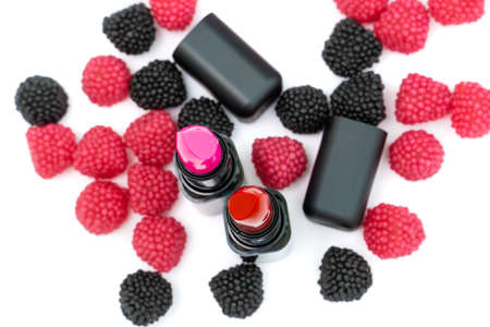 lipstick for lips red and pink colors. candies in the form of raspberries of red and black color on...