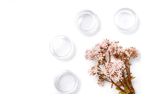 cosmetic packaging for travel. travel cosmetic and bunch of pink flowers on a white backgroundの写真素材