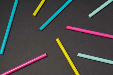 colorful cocktails straw for drinks in pink, yellow, blue colors on a dark backgroundの写真素材