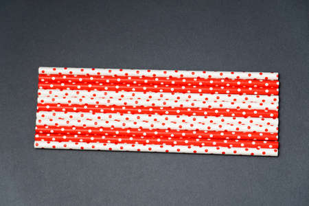 recycled paper straw for drinks red and white colors on a dark background