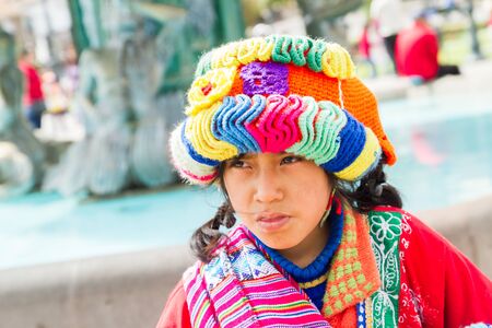 CUSCO - SEPTEMBER 02: Close-up of unknown local peruvian girl with lamb on background of tourists, locals and architectural details on the streets of Cusco, Peru on September 2nd, 2016.のeditorial素材
