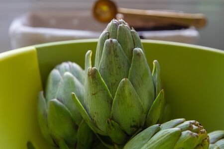 Raw green artichokes i nthe kitchen, ready to be cookedの写真素材
