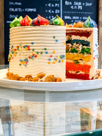 Layered cake celebrating LGBT pride with the rainbow colors and cream
