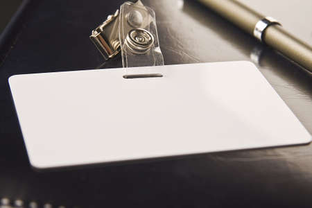 White badge lays on organizer with a black coverの写真素材