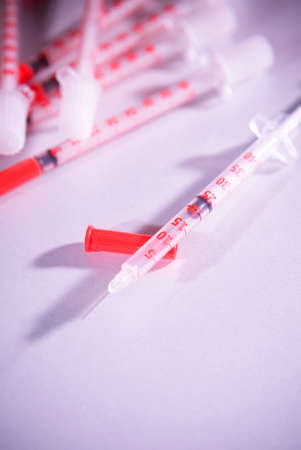 A little small insulinic syringe lies on a red toneの写真素材