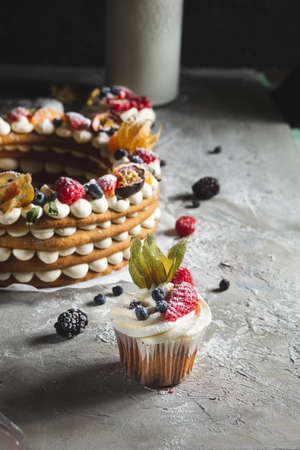 round pie with berries and cupcake on a gray backgroundの写真素材