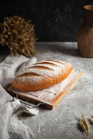 a loaf of bread lies on a wooden gray table
