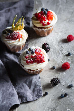 Homemade muffin next to a bottle of milk on a table and on a dark background with fresh berries...