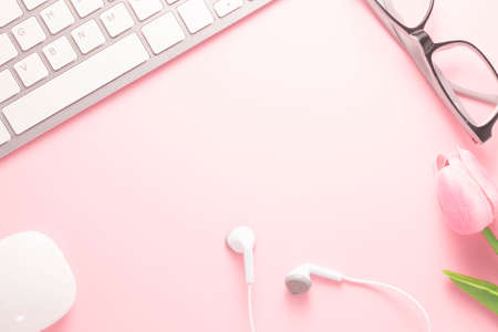 Office desk table top view with office supply, pink table with copy space, pink color workplace composition, flat layの写真素材