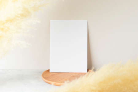 Blank paper cards, Greeting card Mockup with pampas grass on a wooden plate, beige background,...