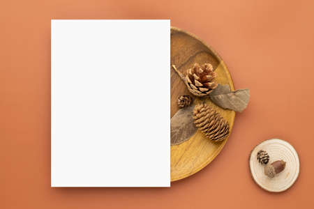 Autumn composition, Blank paper cards Mockup with dried leaves.  and pine cones on brown background. Flat lay, top view with copy spaceの写真素材