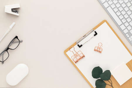 Office desk table top view with office supply, beige table with copy space, beige color workplace composition, flat layの写真素材