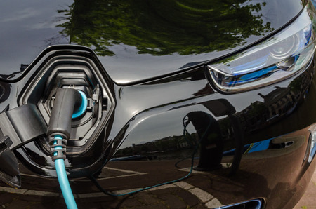 Charging modern electric car with the power supply plugged inの写真素材