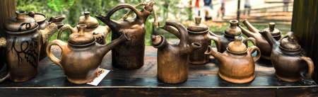 Earthenware teapots are arranged on a wooden window sill.の写真素材