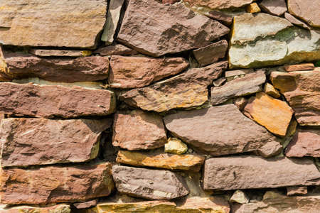 Old wall of stones of different shapes  Close-up 