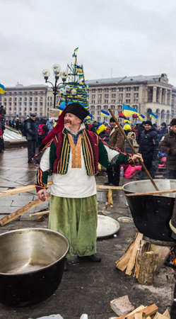 Kiev, Ukraine - December 8, 2013  Elderly man in national dress Cossack prepares food in a large cauldron  On the EuroMaydan のeditorial素材