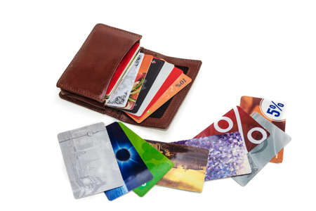 wallet with discount cards and next are a few cards. over white