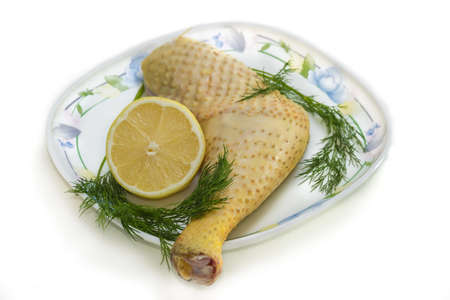 Raw chicken leg poultry grown on the farm, on a platter with lemon and dill on a light background.の写真素材