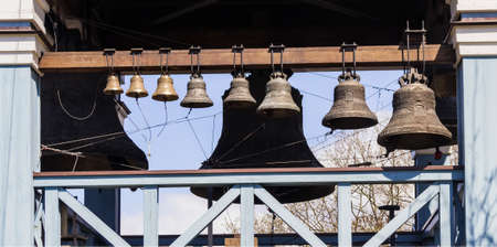 Temple bells of different sizes in the bell tower against the skyの写真素材