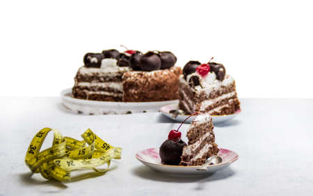 Tape measure and cake in a saucer on the tableの写真素材