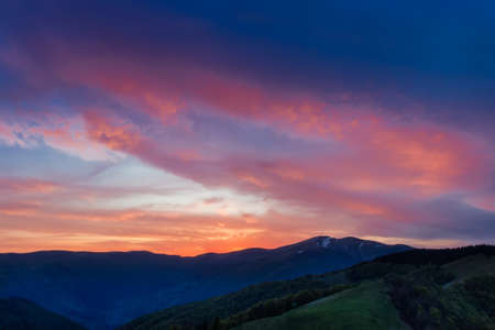 Sky with red, crimson clouds after sunset over the ridge. Carpathians.の写真素材