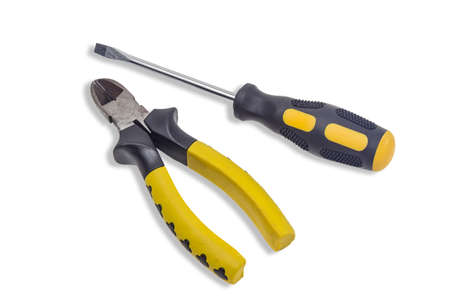 Nippers with a yellow-black handles and flat screwdriver with a yellow-black handle on light background.  Isolation.の写真素材