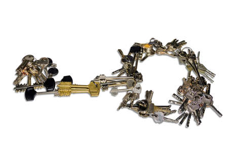Many bunch of different keys to door locks, laid out in the form of a single large key on a light background. Isolation.の写真素材
