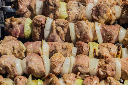 Raw meat with onions, cooked on the grill, closeup.の写真素材