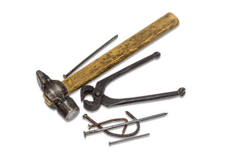 Old hammer pliers for pulling out nails and several different nails on a light . Isolation.の写真素材