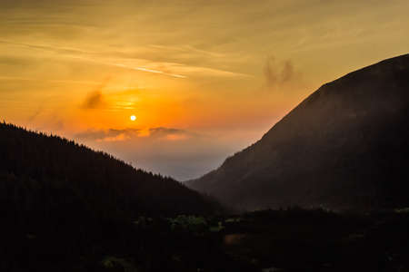 Sunrise in the valley with forested slopes. Carpathians.の写真素材