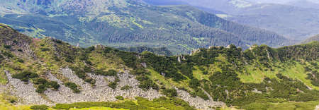 Panorama of one of the mountain ranges of the Carpathians with rocky outcrops, stone placers and bush.の写真素材