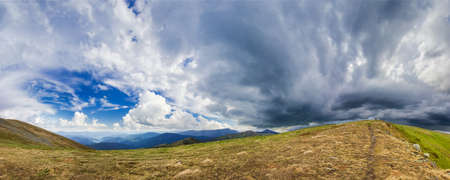 Panorama mountain ranges of the Carpathians against the backdrop of cumulus and storm cloudsの写真素材