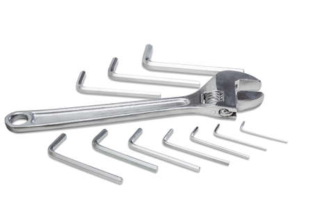Silvery adjustable wrench and set of silvery allen keys different sizes on a light background. Isolation.の写真素材