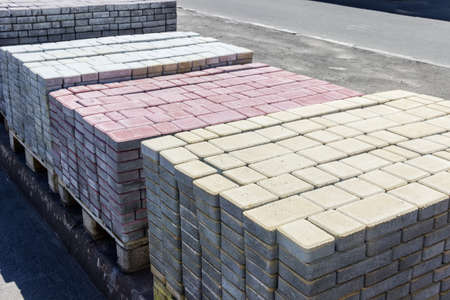 Several wooden pallets with concrete pavers of different colors