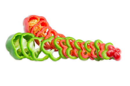 One fresh red and one green bell pepper, part of which is sliced rings on a light background. Isolation.の写真素材