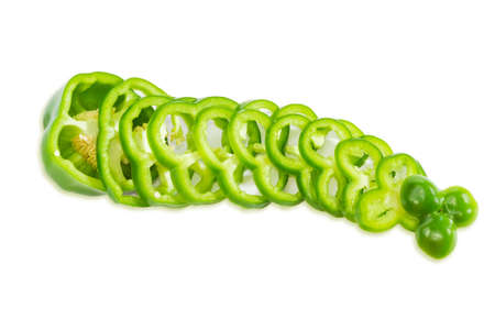 One fresh green bell pepper, part of which is sliced rings on a light background. Isolation.の写真素材