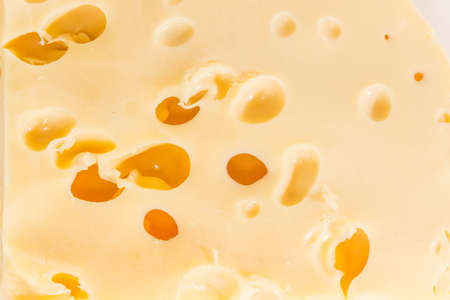 Texture of the semi-hard cheese with large holes closeupの写真素材