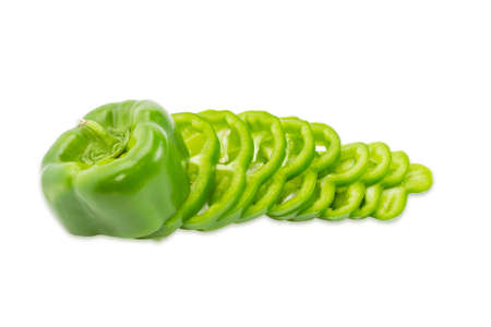 One fresh green bell pepper, part of which is sliced rings on a light background. Isolation.の写真素材