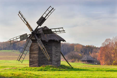 Old windmill on a background of forest and sky in autumn evening. National Museum of Ukrainian Architecture and Culture, Kiev, Ukraine..の写真素材