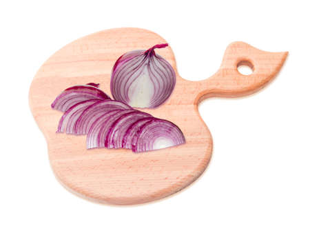 One half of red onion chopped and the other half of a bulb is whole on a cutting board which made of beech wood and has the form of apple. Isolation on a light backgroundの写真素材