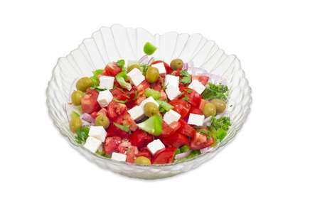 Greek salad in a glass salad bowl on a light backgroundの写真素材