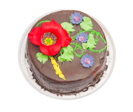 Round sponge cake, covered with chocolate glazing on top tameing floral ornament. On a light backgroundの写真素材