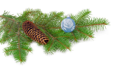 Branch of a fir tree with cone and Christmas ornaments on a light backgroundの写真素材