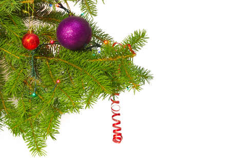 Branches of a Christmas tree with Christmas ornaments and Christmas mini lights on a light backgroundの写真素材
